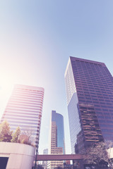 Vintage toned photo of Denver downtown skyscrapers against sun, Colorado, USA.