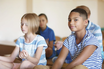Schoolchildren in lotus position relaxing on lesson