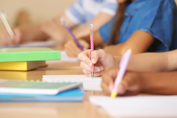 Children hands writing in copybooks, closeup