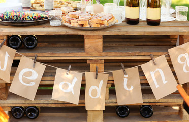 Decorated wedding table with snacks and champagne outdoors