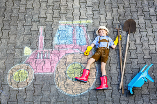 little kid boy having fun with tractor chalks picture