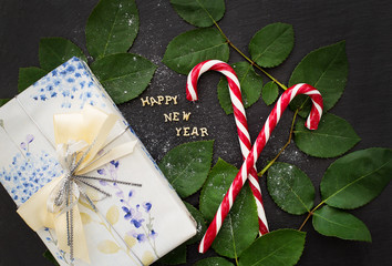 inscription of new year on a black board with  nice gift and red candy
