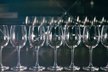 Row of empty wine glasses on bar counter