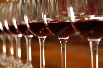 Row of glasses with red wine on bar counter, closeup