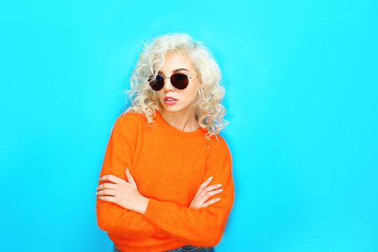 Portrait of funny girl in glasses on blue background