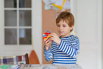 school kid boy playing with lots of small colorful plastic blocks