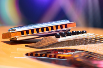 Detail of guitar strings with supported harmonica for country mu