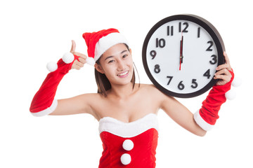 Asian Christmas Santa Claus girl  thumbs up with clock at midnig