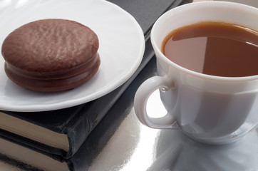 White cup with cocoa and chocolate covered biscuit