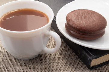 White cup with cocoa and chocolate biscuit