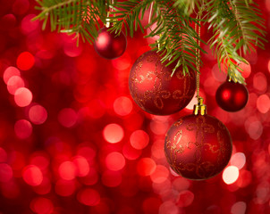Christmas Baubles on red background with sparkles .