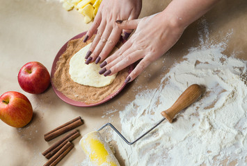 Preparation cookies with cinnamon, cottage cheese and apples on kraft paper. Female hands rolling dough in sugar. Homemade pastries. Christmas tradition baking, cakes biscuits.