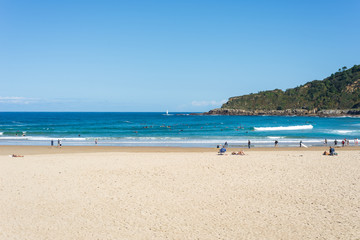 Fototapeta na wymiar Surfer do water sport, people relax at the beach La Zurriola in Donostia San Sebastian. The beach is situated at the district Gros of San Sebastian. The beach is famous for surfing,sports and relaxing