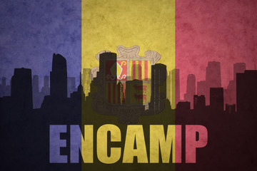 abstract silhouette of the city with text Encamp at the vintage andorran flag