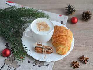 Cup of cappuccino with christmas decorations on wooden table