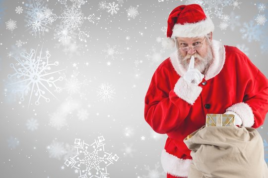 Composite image of santa claus with finger on lips and holding g