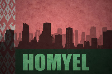 Fototapeta premium abstract silhouette of the city with text Homyel at the vintage belarus flag