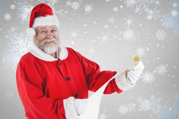 Composite image of portrait of santa claus smiling and holding s