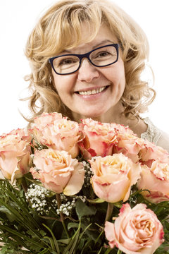 Beautiful, blond mature woman with bunch of roses