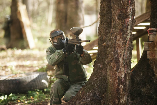 A man in mask for paintball. In forest.