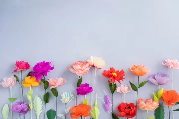 Foto op Aluminium Colourful handmade paper flowers on light blue background with copyspace © Elisabeth Cölfen