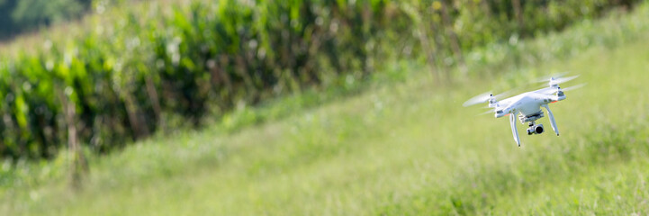 Quadcopter drone flying over a cultivated field