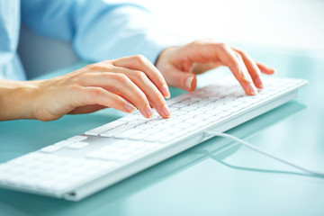 Fototapeta na wymiar Woman office worker typing on the keyboard