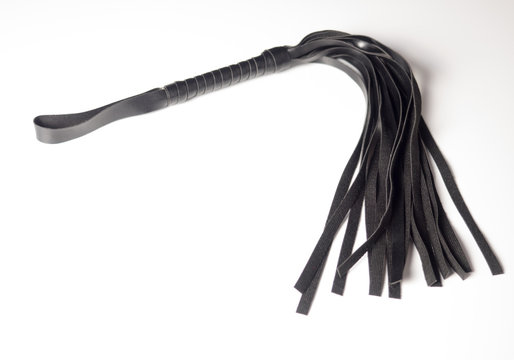 Black leather whip on white background (for sadomasochism, bondage and domination)
