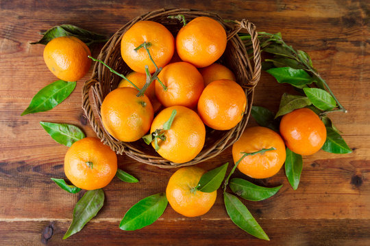 Tangerines basket over old wooden table top view