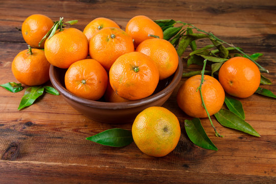 Mandarins tangerines in brown ceramic bowl