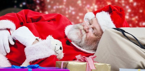 Composite image of close-up of tired santa claus sleeping beside