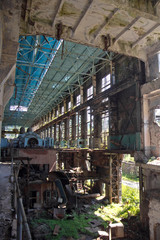 Fototapeta na wymiar Abandoned, destroyed by war and overgrown machinery of Tkvarcheli power plant 