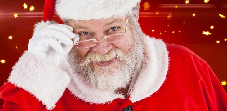 Composite image of santa claus holding spectacles