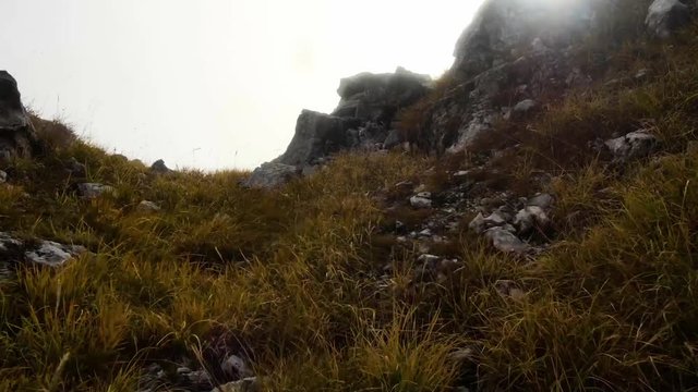 motion along the rocky terrain in autumn misty mountains