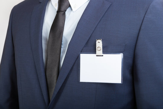 Businessman wearing a blank ID tag or name card during an exhibition or a conference