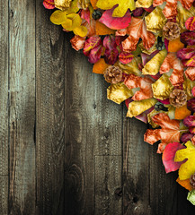 Autumn Leaves over a Natural Dark Wooden background. Old dirty wood tables or parquet with knots and holes and aged partculars.