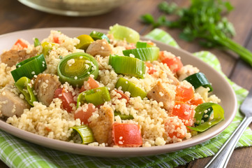 Couscous mit Hähnchen, Tomate und Lauch, fotografiert mit natürlichem Licht (Selektiver Fokus,...