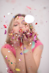 woman blowing confetti in the air