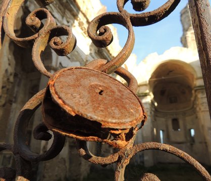 scorcio di antica chiesa scoperchiata con cancello chiuso da antico lucchetto arrugginito