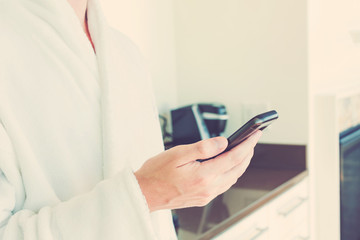 Man in a bathrobe using his smartphone