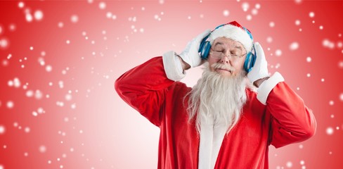 Composite image of santa claus listening to music on headphones 