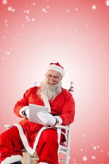 Composite image of santa claus playing game on digital pc