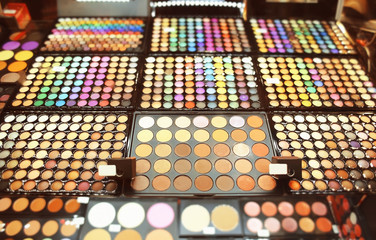 Assortment of different colourful eye shadow palettes in cosmetic store