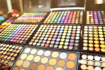 Assortment of different colourful eye shadow palettes in cosmetic store
