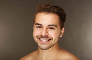 Portrait of young handsome man on grey background