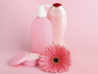 Fototapeta na wymiar Spa concept. Cosmetic products and beautiful flower on pink background