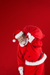 Composite image of portrait of santa claus holding christmas bag