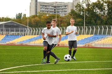 Boys playing football at stadium