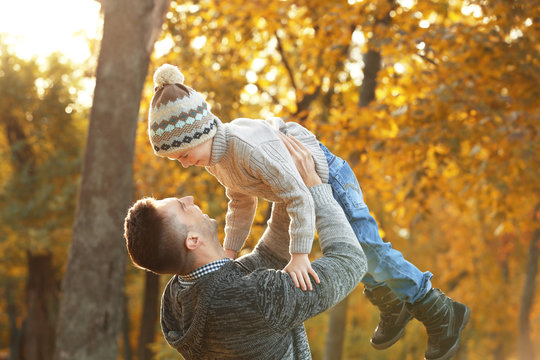 Father and son playing in beautiful autumn park