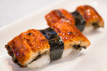 Nigiri sushi with roasted eel unagi on white background